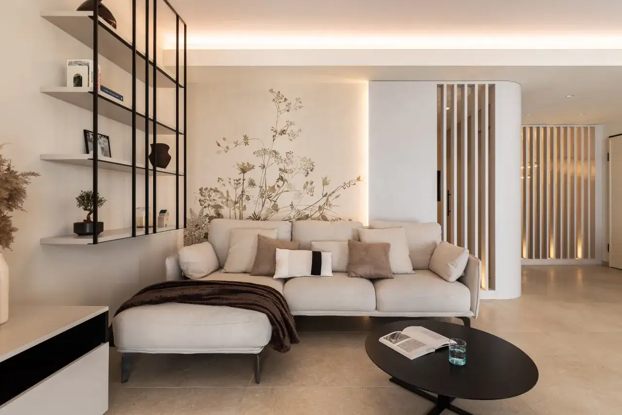Gemütliches Wohnzimmer mit beiger Couch, floraler Wandtapete und moderner Regalwand. Perfekte wohnung inspo für ein stilvolles Zuhause.