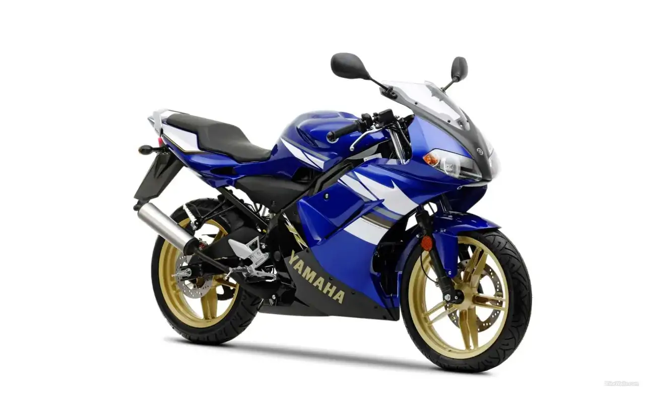 Niebieski motocykl Yamaha TZR 125 z złotymi felgami, gotowy do jazdy z maksymalną prędkością.