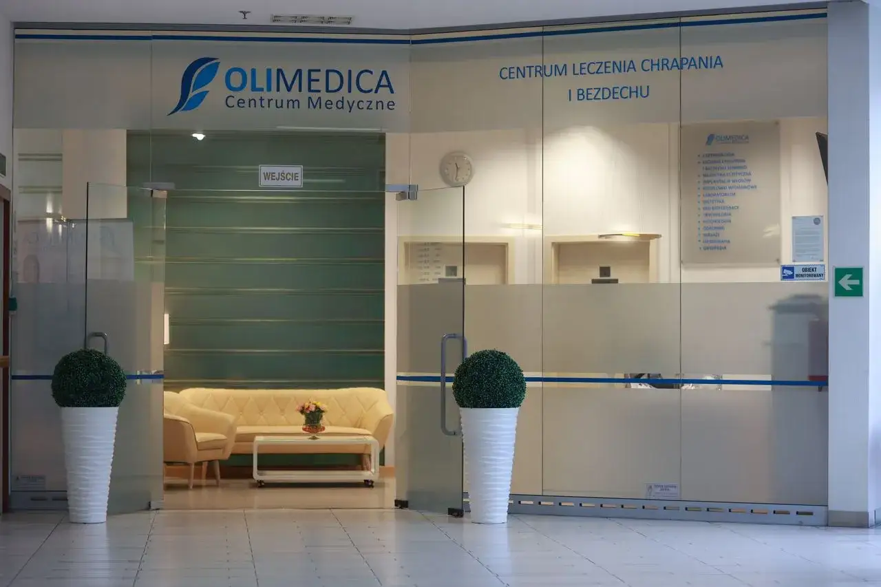 Wejście do centrum medycznego Olimedica z kanapą i roślinami w donicach.