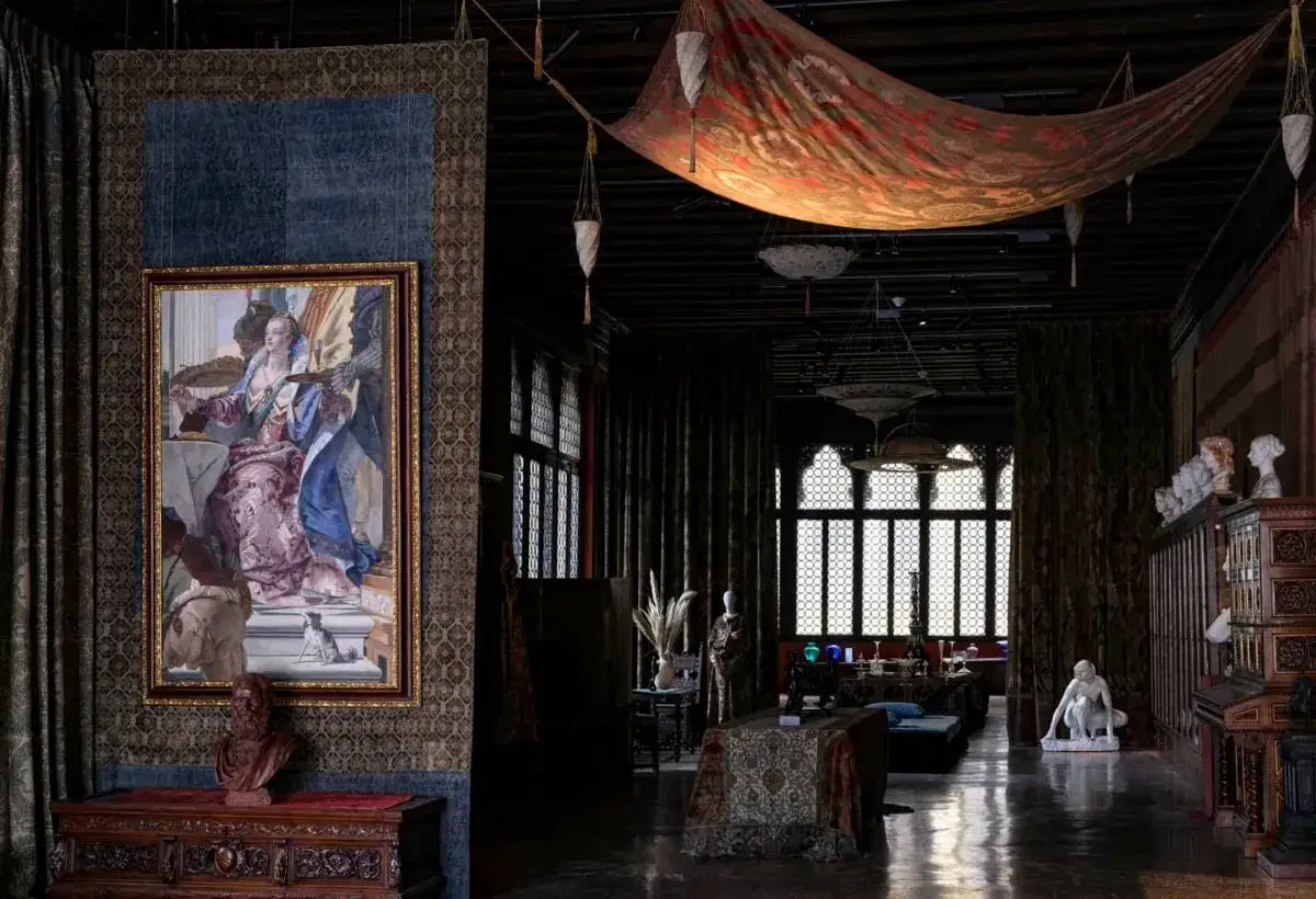 Interno sontuoso di una casa museo a Venezia, con un grande dipinto, tessuti preziosi e arredi d'epoca.