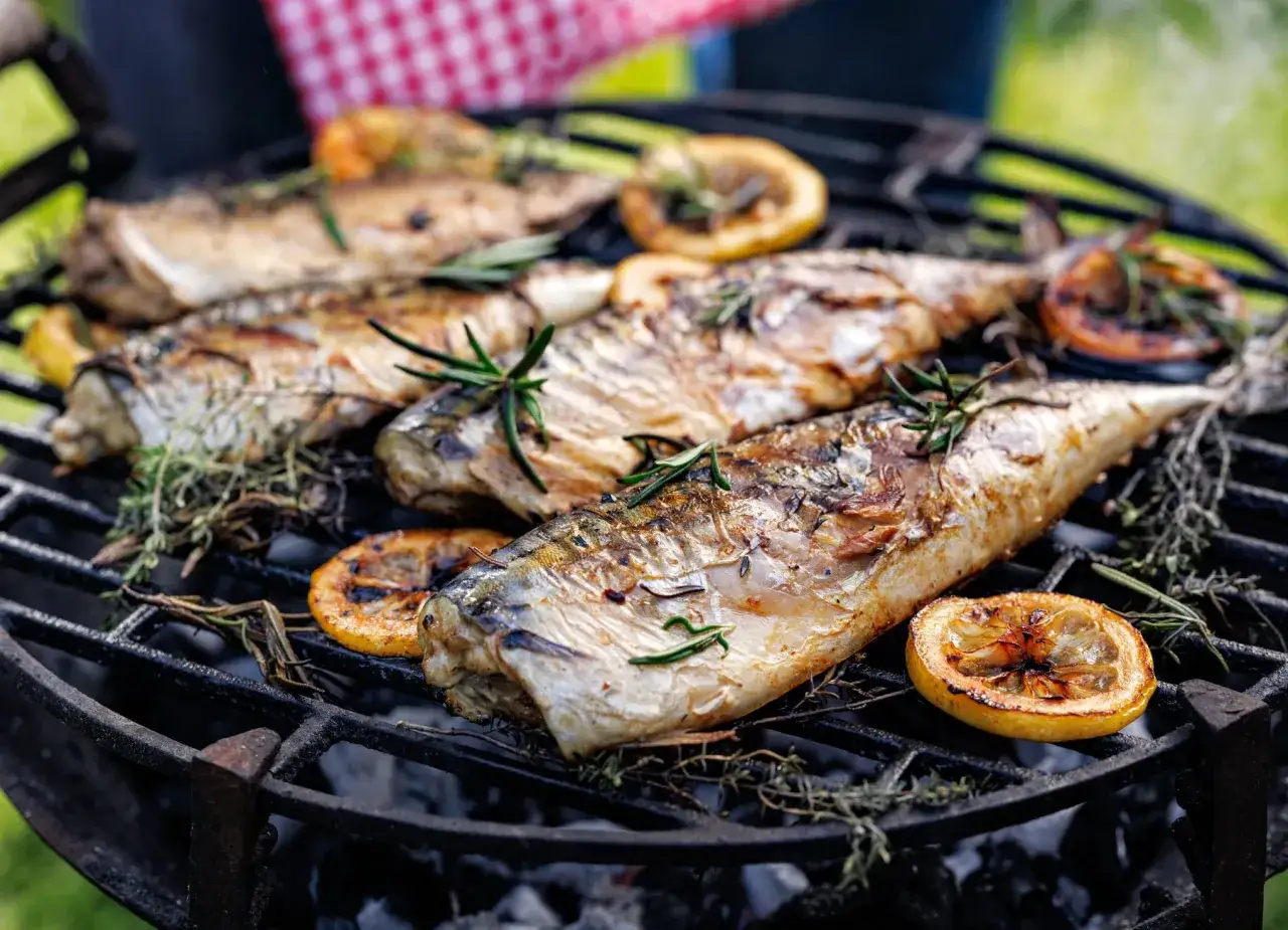 Maquereaux grillés sur un barbecue Weber, avec des herbes et des rondelles de citron. Le temps de cuisson parfait pour un repas savoureux.