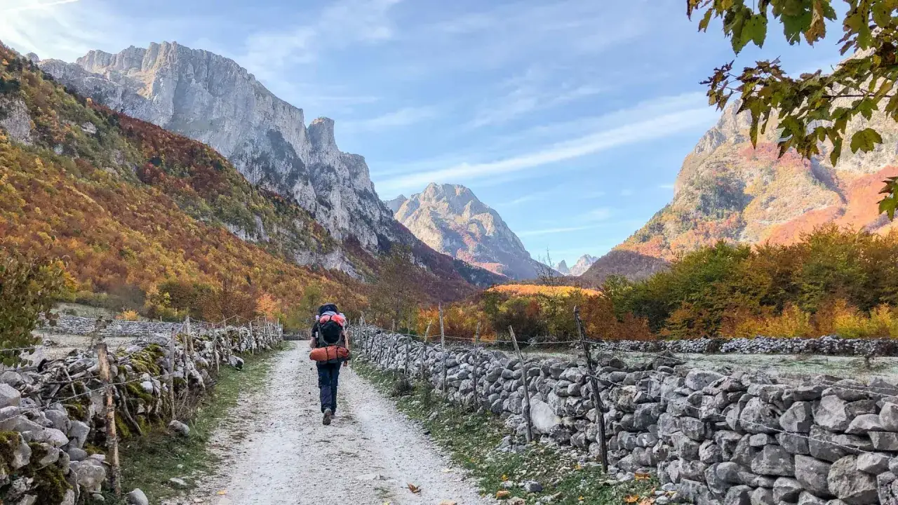 Wanderer auf dem Weg durch die bunten Herbstw&auml;lder zu den **peaks of the balkans auf eigene faust**.