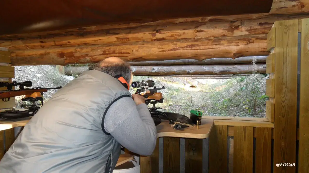 Un tireur sportif vise avec une carabine. L'interdiction du plomb tir sportif est une préoccupation croissante pour la protection de l'environnement.