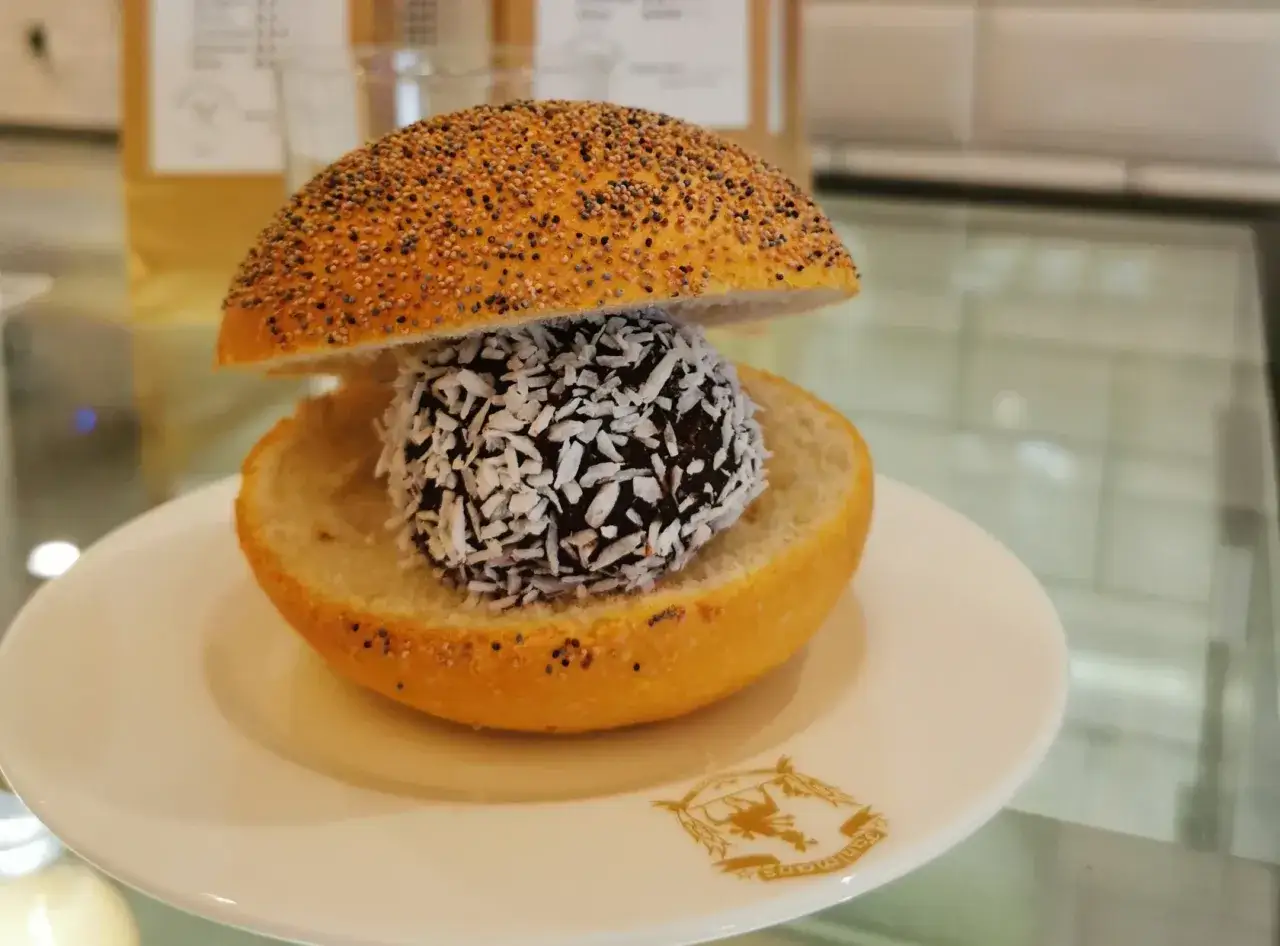 En bulle med bulle: en chokladboll med kokosflingor inuti en delad bulle med vallmofrön.