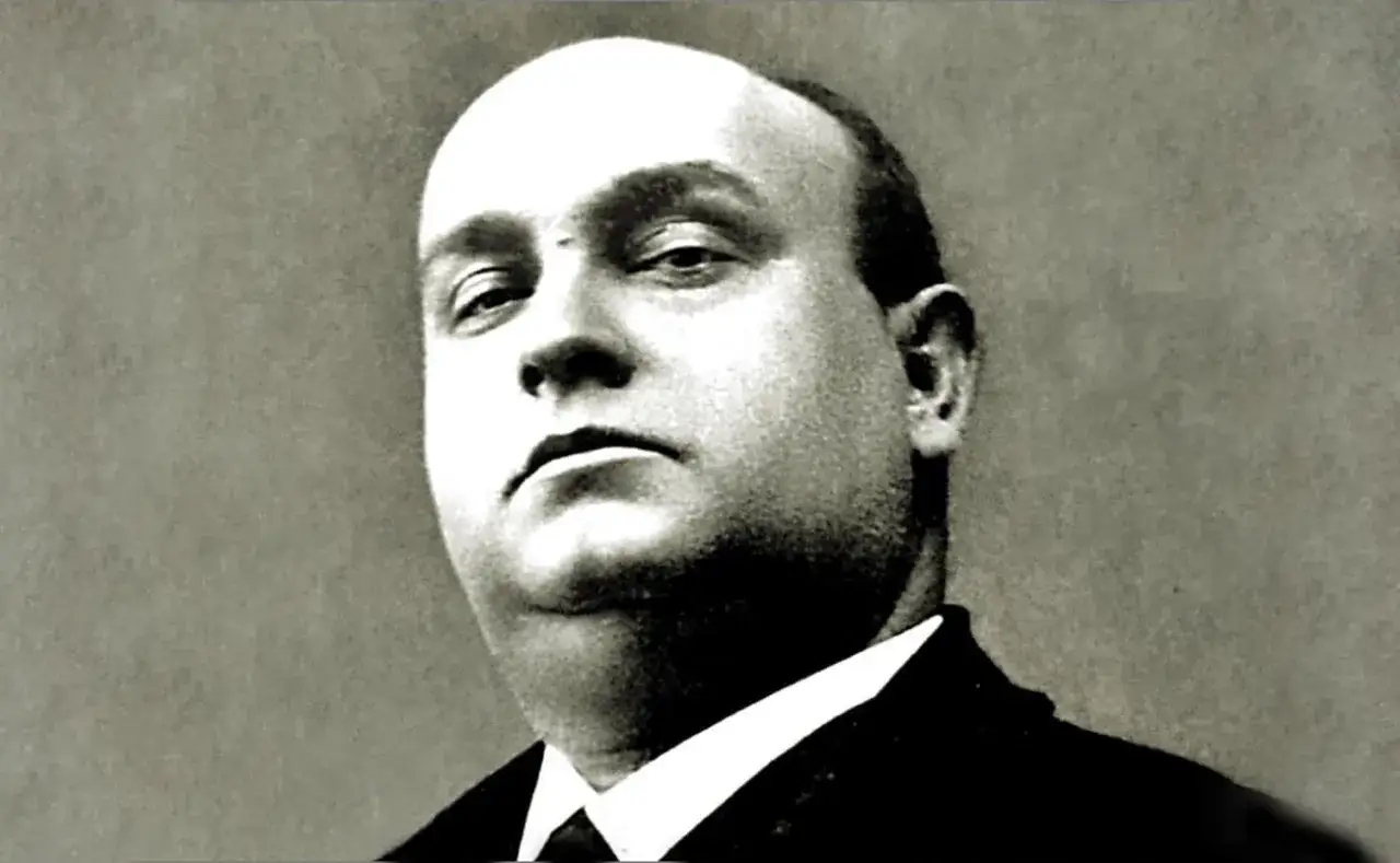 Retrato de Antonio, cantante flamenco, con mirada intensa y traje oscuro.