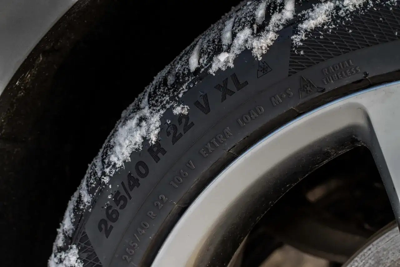 Gomma invernale con neve sul battistrada. La sigla gomme invernali indica le dimensioni 265/40 R 22 XL, perfette per affrontare il freddo.
