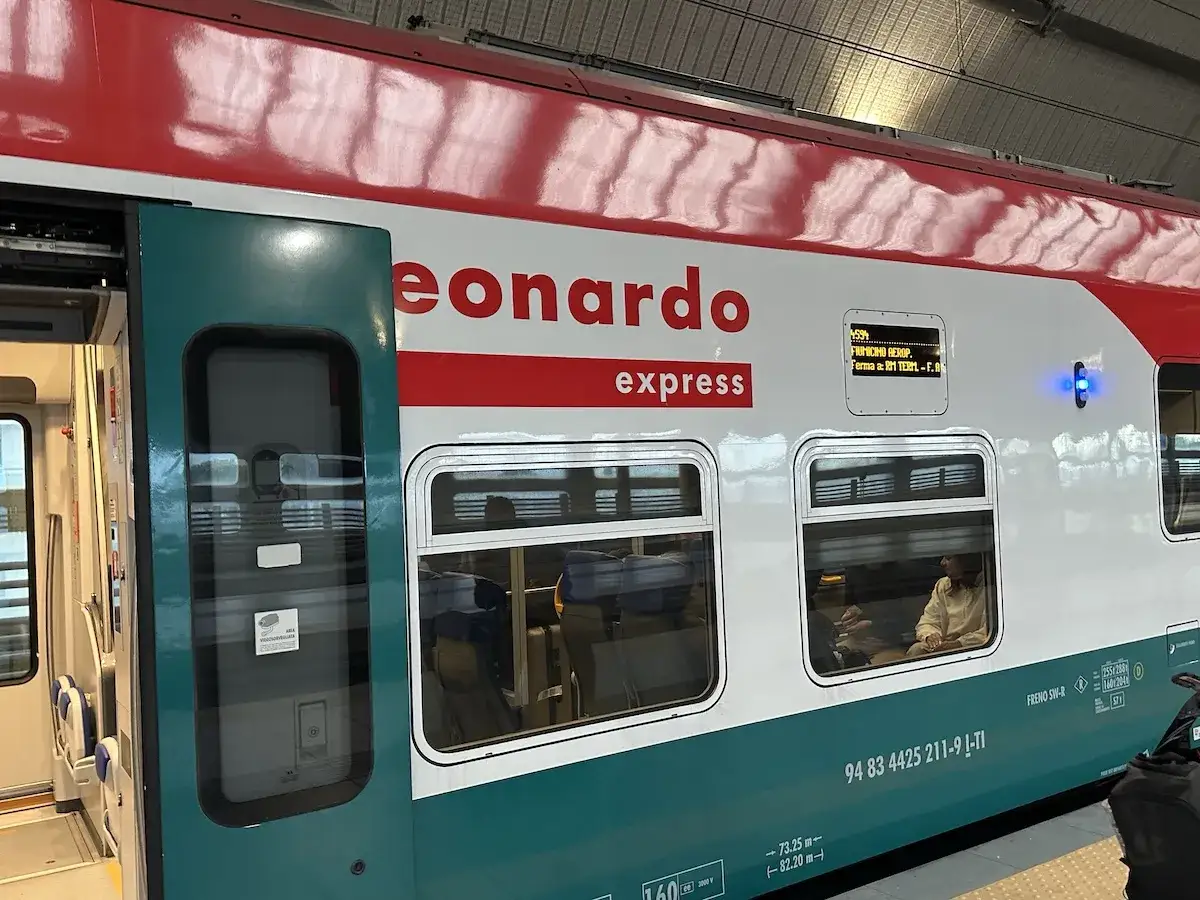 Pociąg Leonardo Express do Fiumicino Aeroporto stoi na stacji.