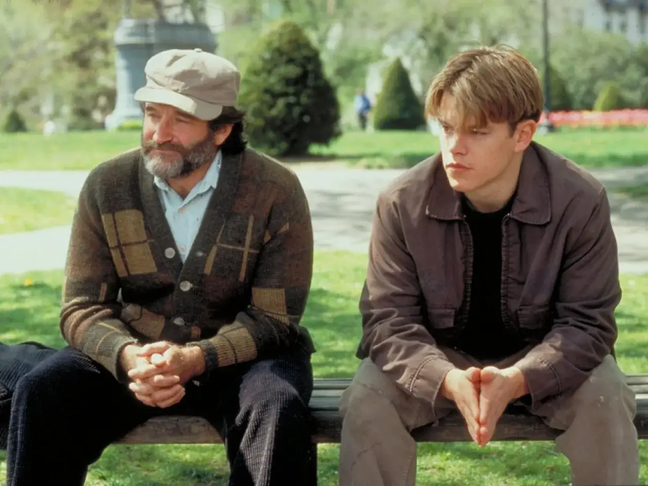 Matt Damon i Robin Williams siedzą na ławce w parku, scena z jednego z ich wspólnych filmów.