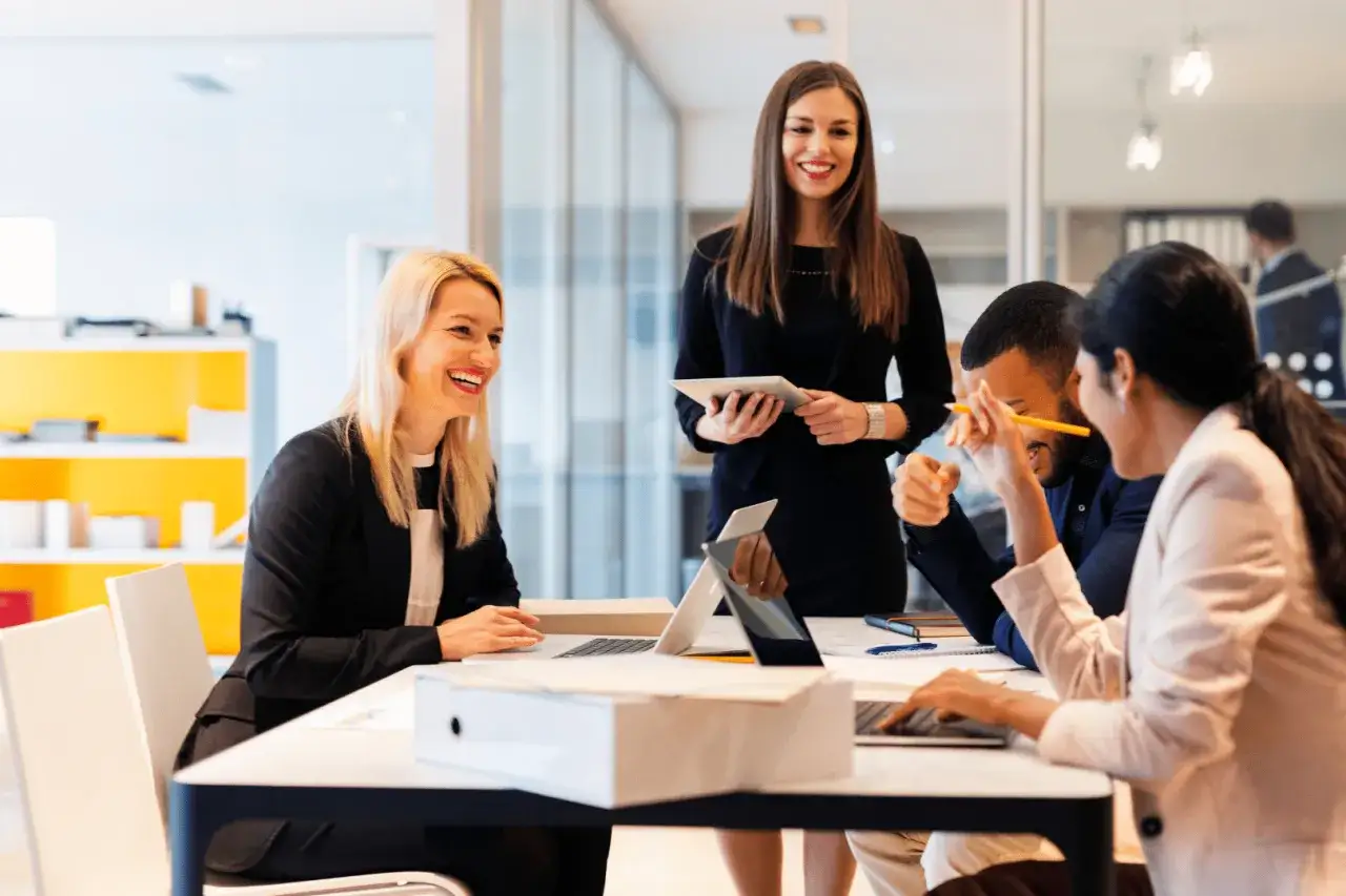 Equipo colaborando, mostrando un alto coeficiente emocional. Risas y trabajo en equipo en la oficina.