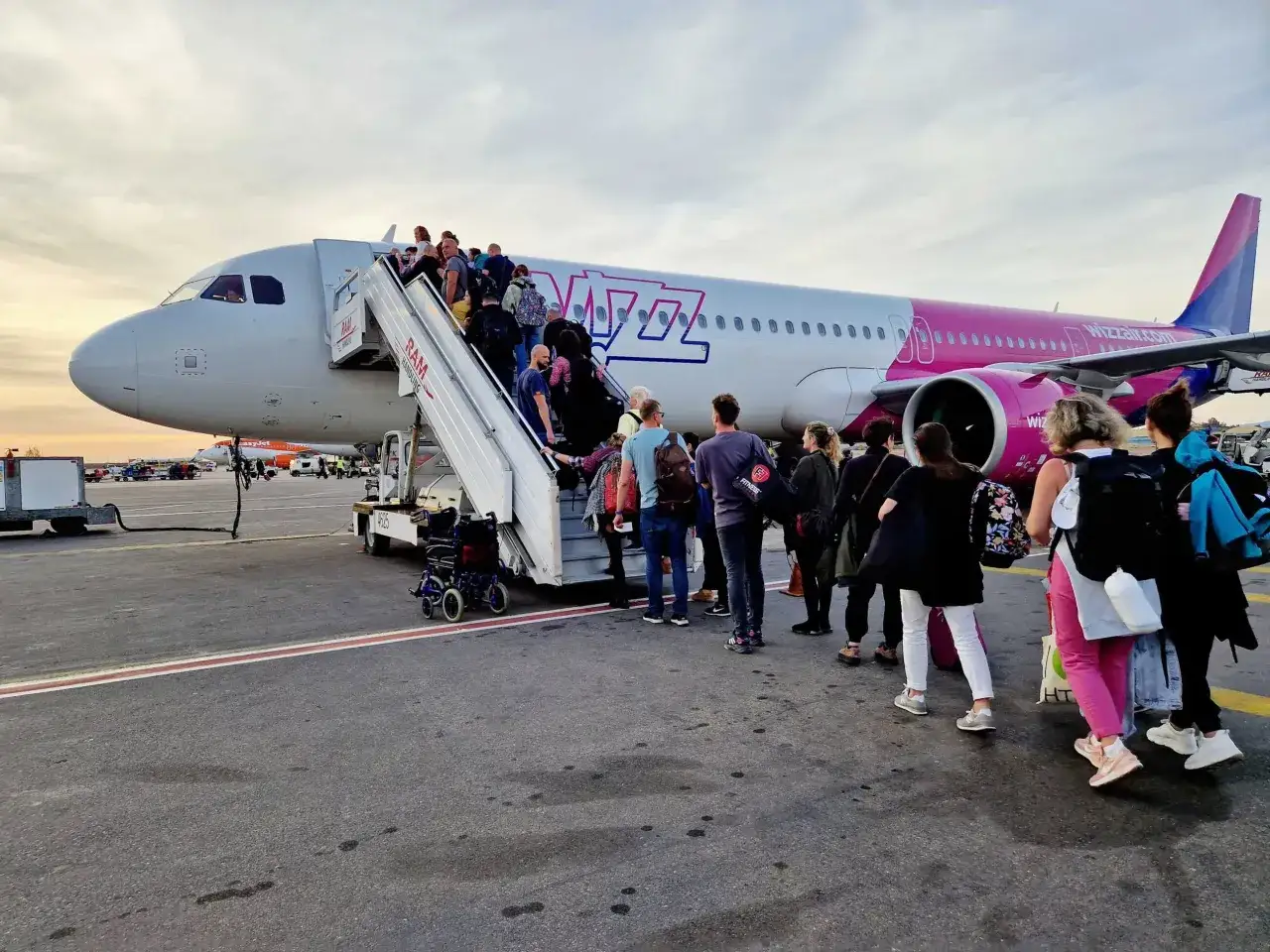 Pasażerowie wsiadają do samolotu Wizz Air. Ciekawe, ile się leci do Albanii na wakacje.