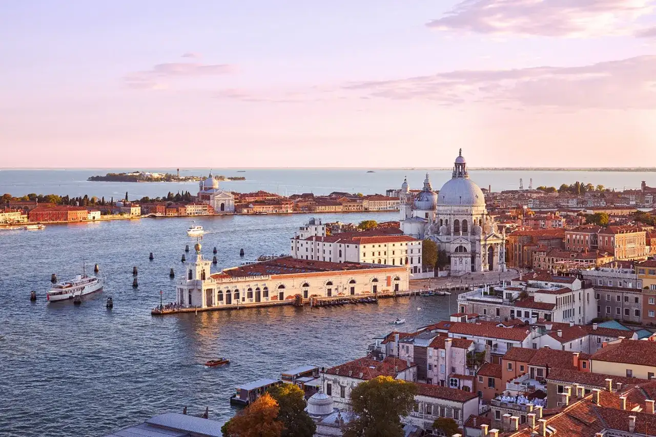 Vista aerea di Venezia al tramonto, con la Basilica di Santa Maria della Salute e la Dogana da Mar in primo piano.