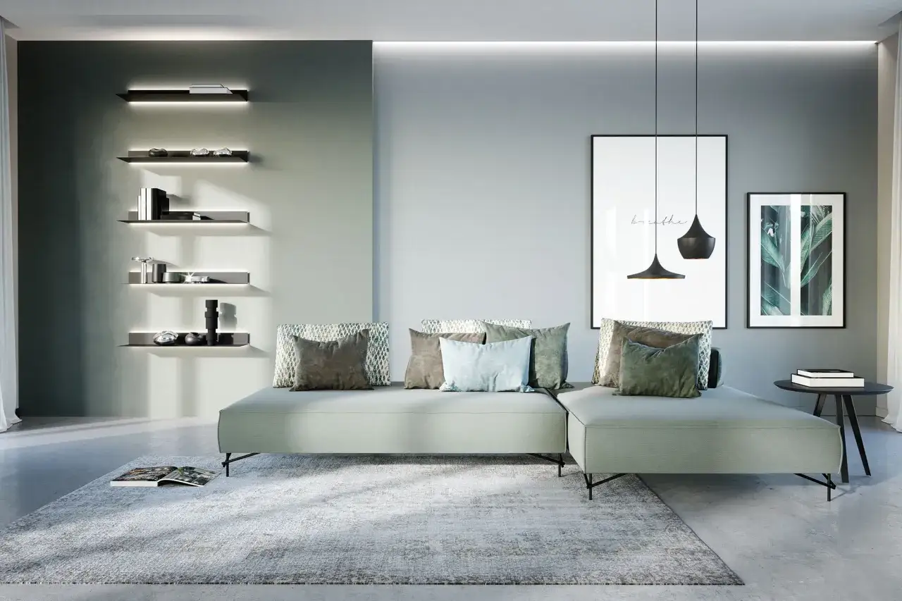 Soggiorno moderno con divano angolare verde menta, cuscini decorativi e parete con mensole illuminate. Ottime idee colori pareti per un ambiente rilassante.
