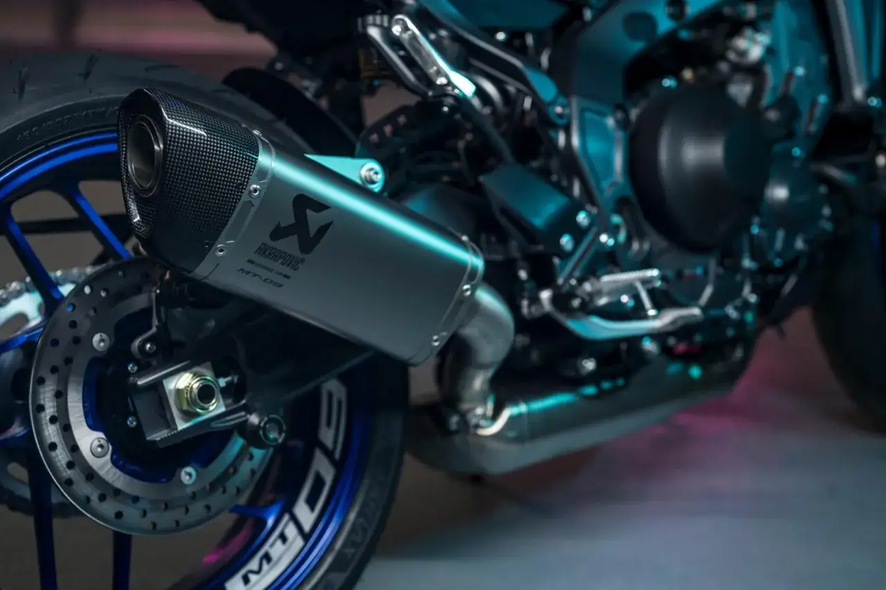 Wydech Akrapovič na motocyklu Yamaha MT-09, z karbonową końc&oacute;wką i niebieskimi detalami felgi.