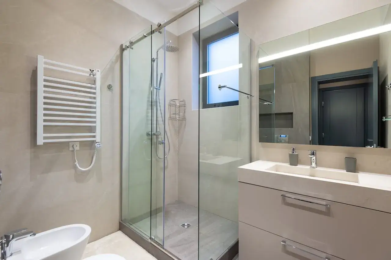 Ba&ntilde;o moderno con ducha de cristal, lavabo y bidet. El plato de ducha est&aacute; impecable, listo para disfrutar.
