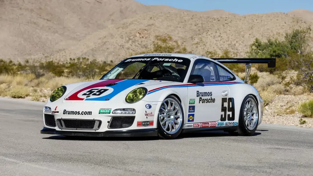 Weißer 997 GT3 Cup mit Startnummer 59 und Brumos Porsche-Lackierung, bereit für die Rennstrecke in der Wüste.