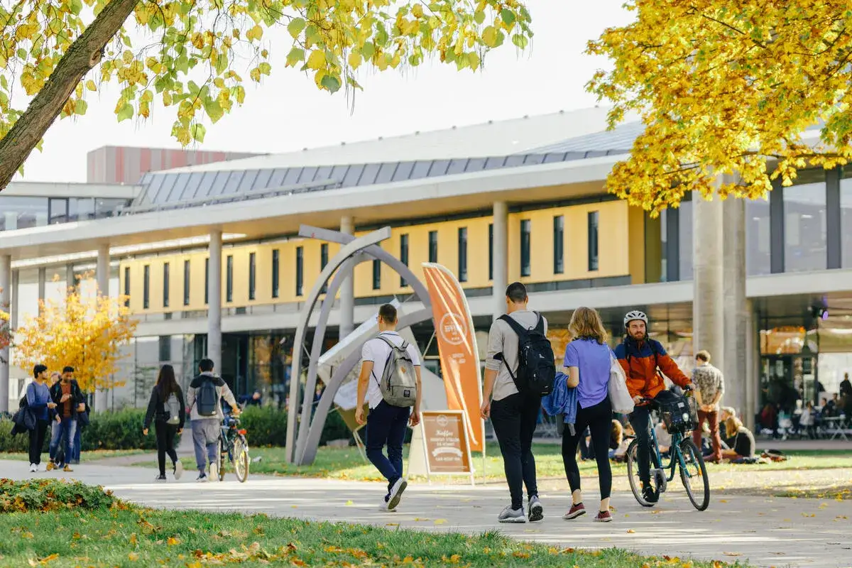 Herbstliche Szene auf dem Campus. Studierende gehen zur Uni, um in Magdeburg zu studieren.