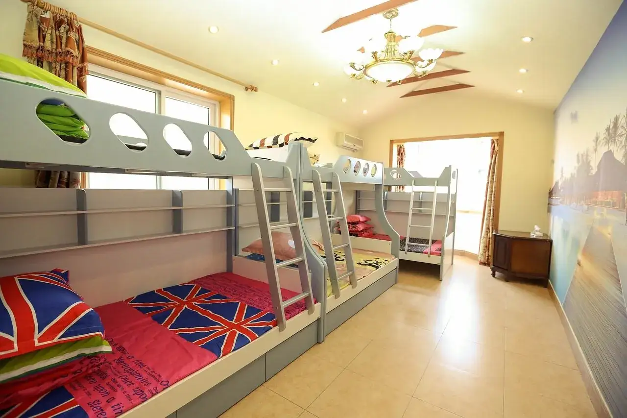 Chambre colonie de vacances avec plusieurs lits superposés. Les draps sont décorés du drapeau britannique.