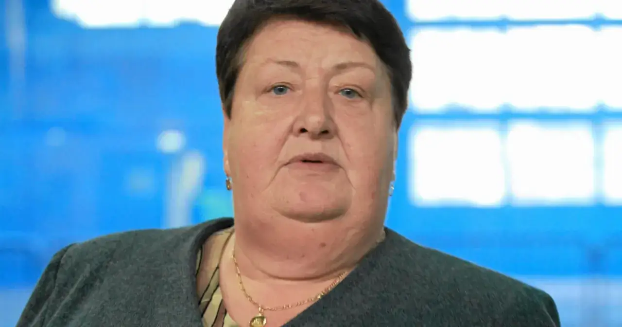 Portret Henryki Krzywonos Strycharskiej, działaczki opozycji antykomunistycznej, z niebieskim tłem.