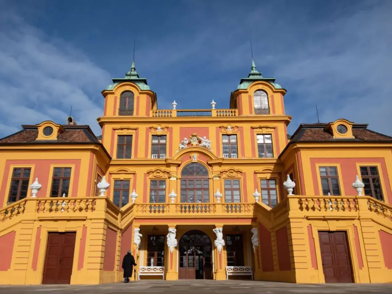 Prachtvolles barock schloss Ludwigsburg mit gelber Fassade und grünen Kuppeln unter blauem Himmel.
