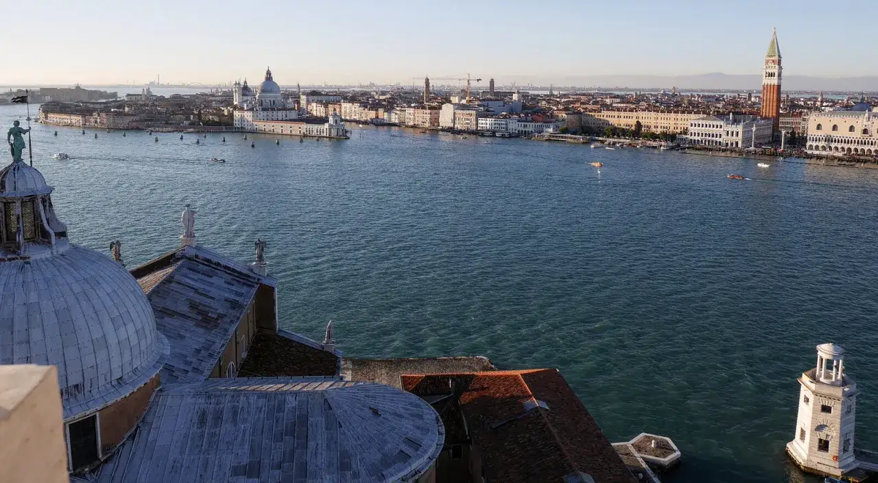 Vue de Venise avec le campanile de San Giorgio Maggiore dominant l'horizon. Des d&ocirc;mes et des toits se d&eacute;tachent sur l'eau bleue.