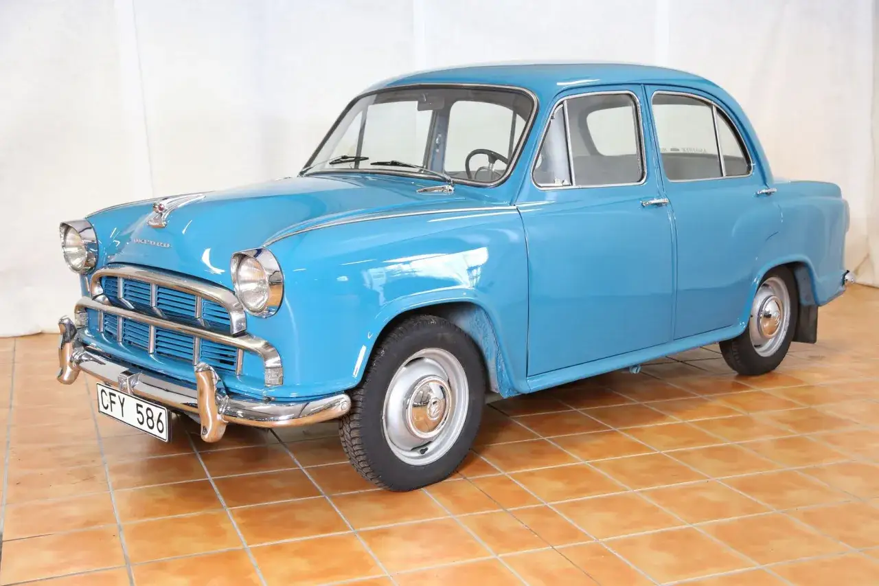 En blå Morris Oxford från 1950-talet står på ett orange kakelgolv.