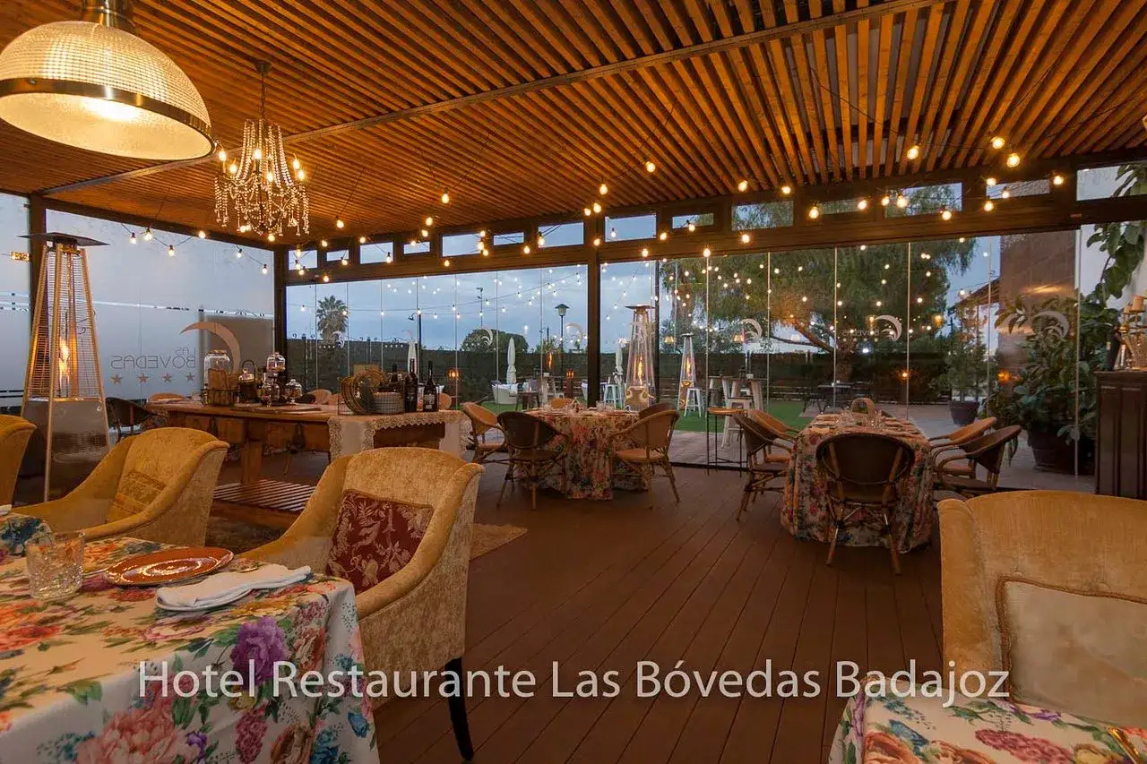 Ambiente acogedor en uno de los mejores restaurantes de Badajoz, con mesas florales y luces cálidas.