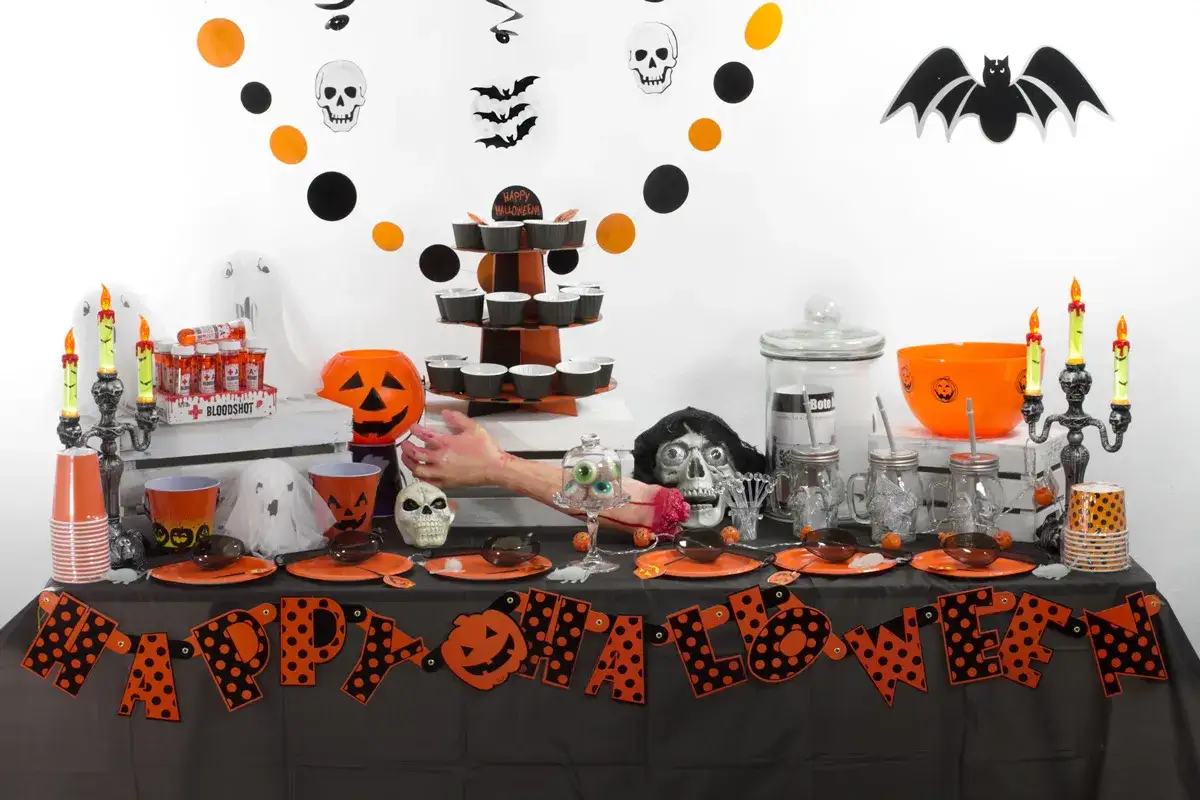 Mesa de **manualidades chuches Halloween** con calabazas, fantasmas, calaveras y dulces.