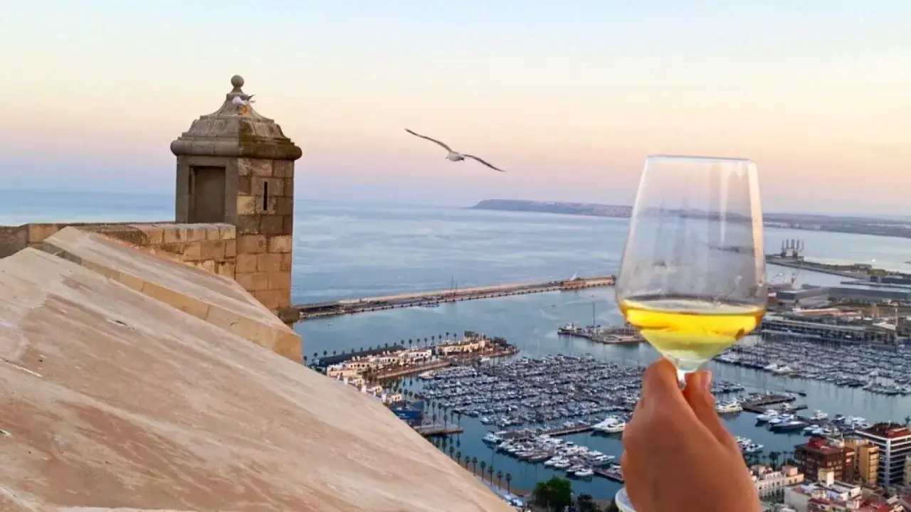 Copa de vino blanco con vista al puerto de Alicante. Un d&iacute;a perfecto para catas alicante.