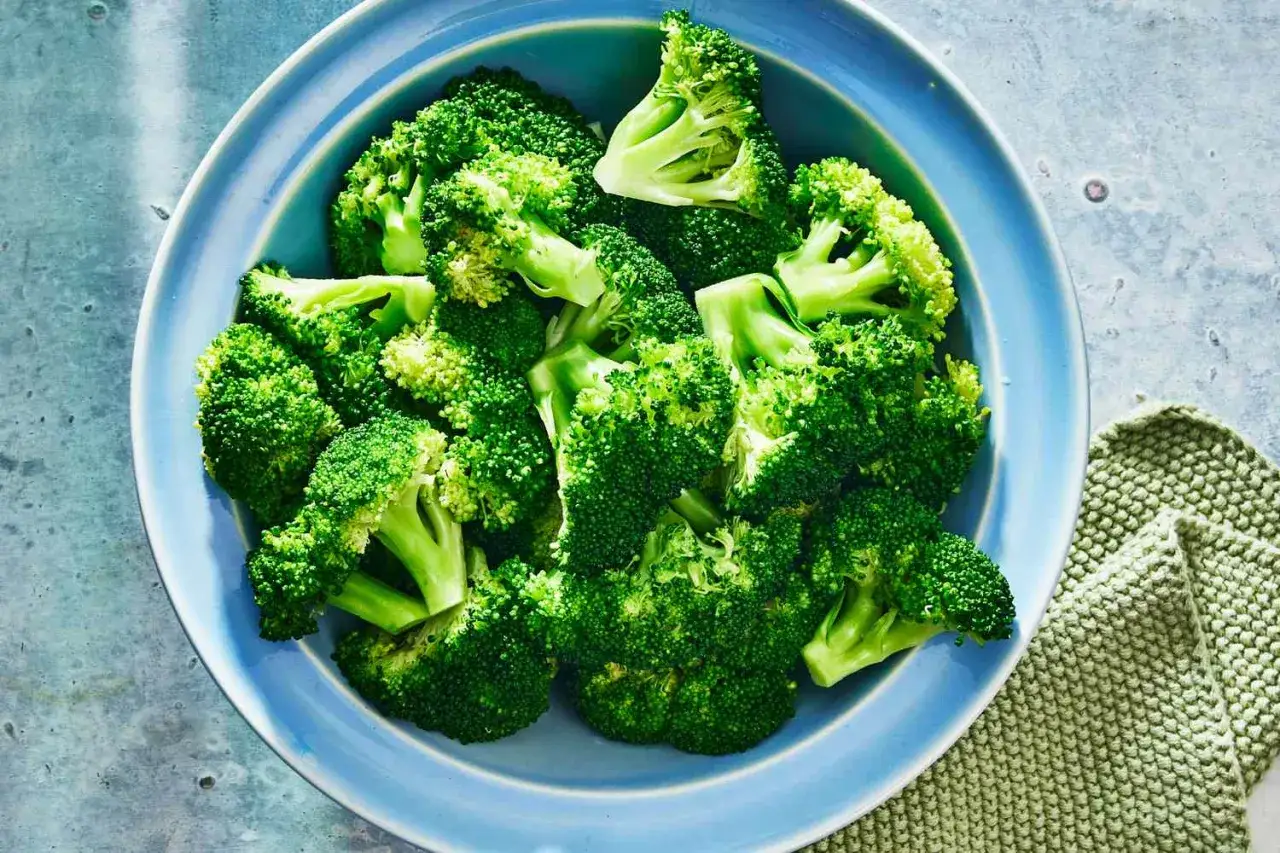 Blanchera broccoli i en blå skål, redo för en hälsosam måltid.