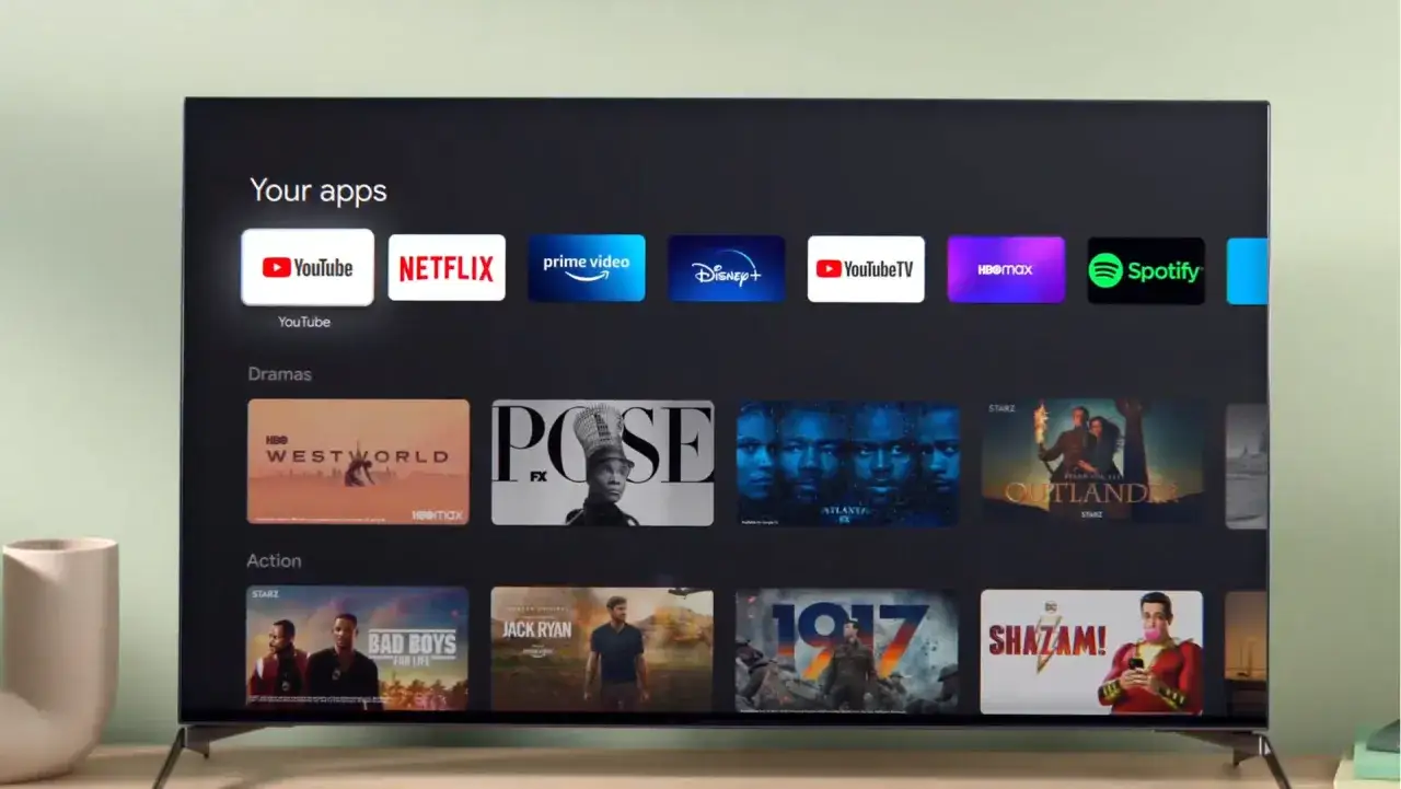 Ekran Google TV z aplikacjami: YouTube, Netflix, Prime Video, Disney+, YouTube TV, HBO Max, Spotify. Poniżej sekcje