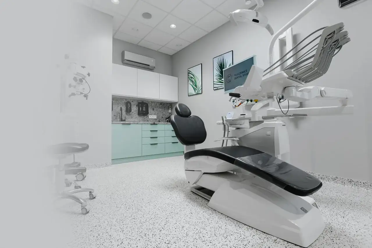 Nowoczesny gabinet stomatologiczny z fotelem dentystycznym i mikroskopem.