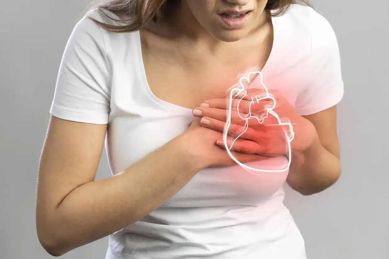 Une femme ressent une douleur aiguë, un pincement poitrine gauche, avec une illustration du cœur en surbrillance.
