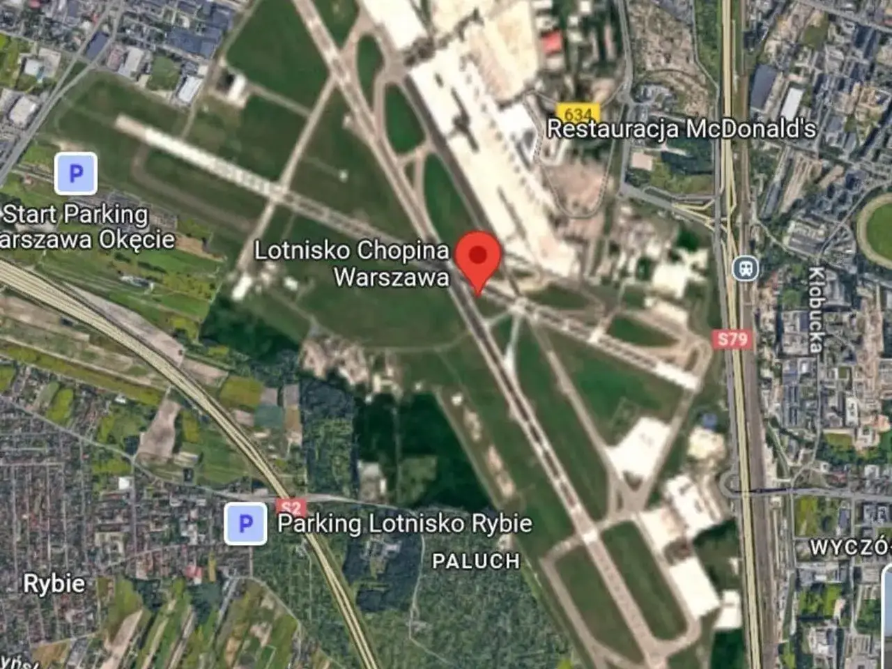 Widok z lotu ptaka na Lotnisko Chopina Warszawa. Widać pasy startowe, parkingi i drogę S79.