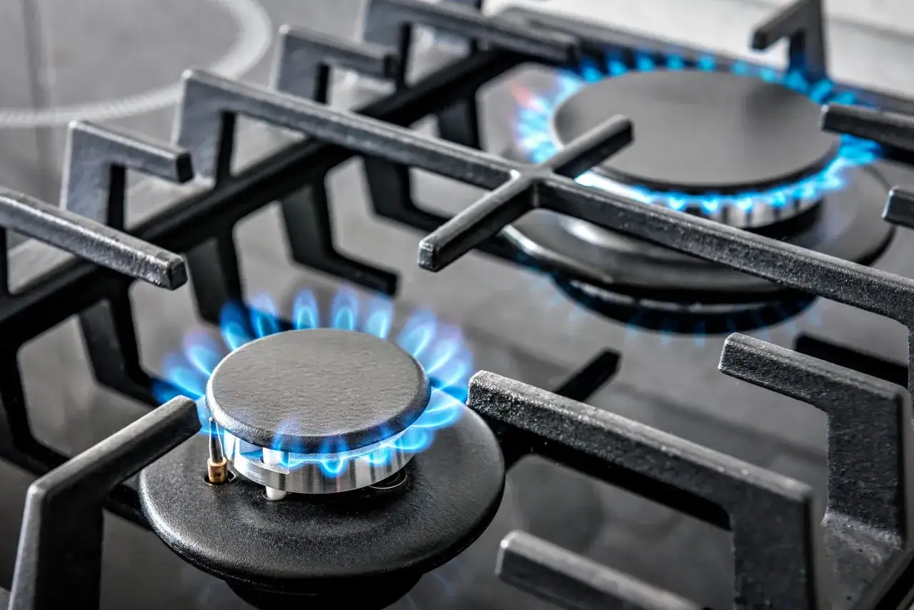 Fiamme blu danzano sul fornello a gas, pronte a scaldare. La fiamma gialla del gas caldaia è un ricordo lontano.
