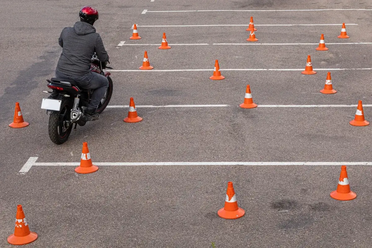 Motocyklista na placu manewrowym z pachołkami. To może być egzamin kontrolny po utracie prawa jazdy za punkty.