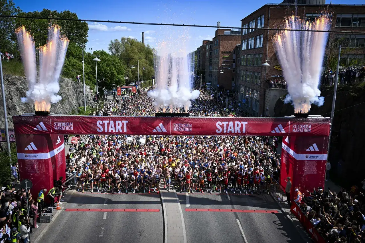 Startskottet f&ouml;r rekord Stockholm Marathon avfyras med fyrverkerier. Tusentals l&ouml;pare redo vid startlinjen.
