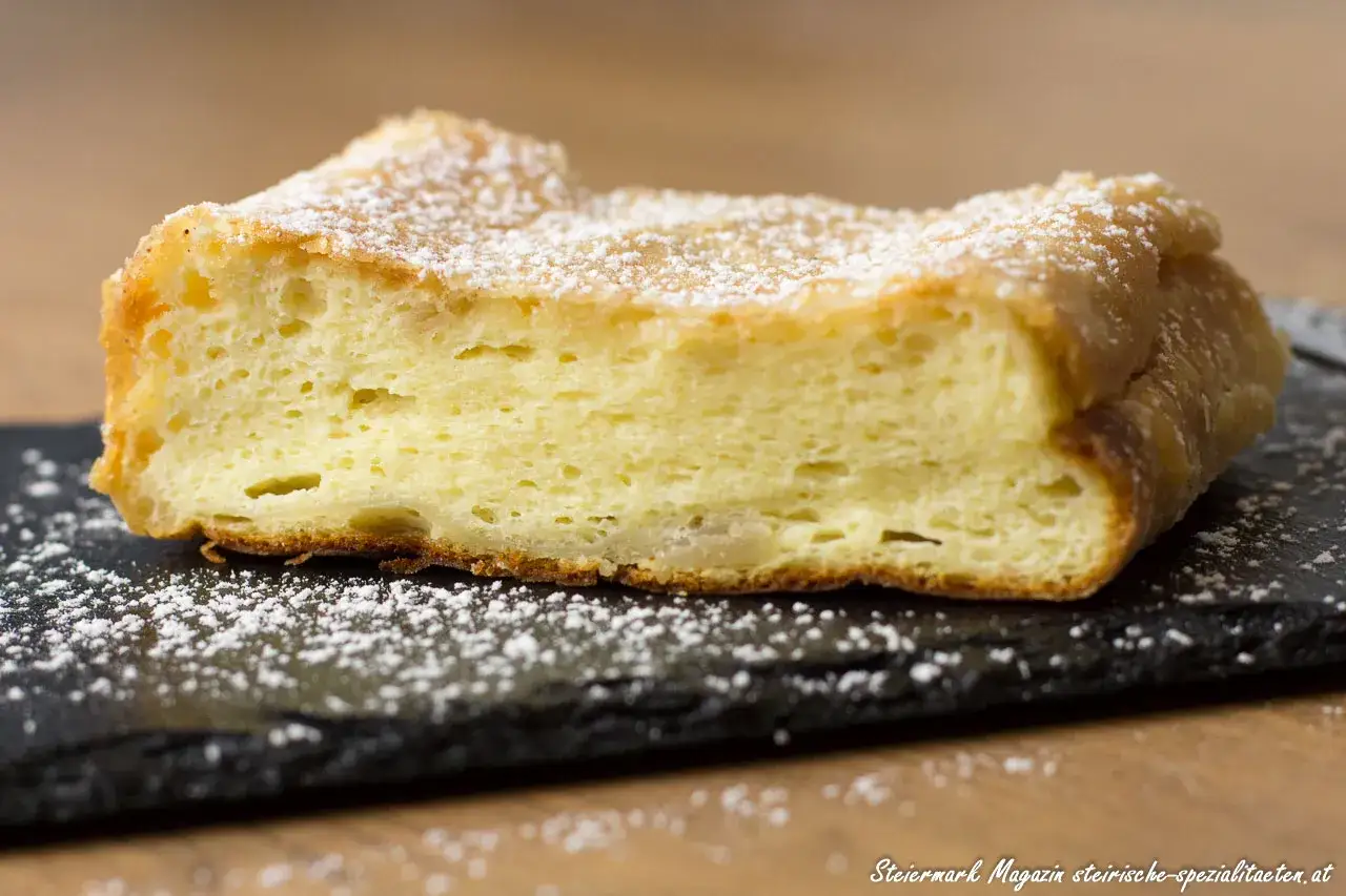 Ein Stück fluffiger Topfenstrudel, bestäubt mit Puderzucker. Perfekt für ein gemütliches Topfenstrudel Rezept.