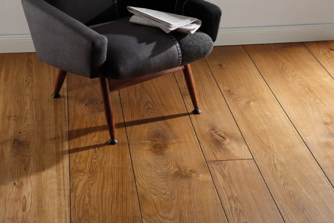 Silla oscura sobre suelo de madera con vetas marcadas, mostrando diferentes tipos de parquet.