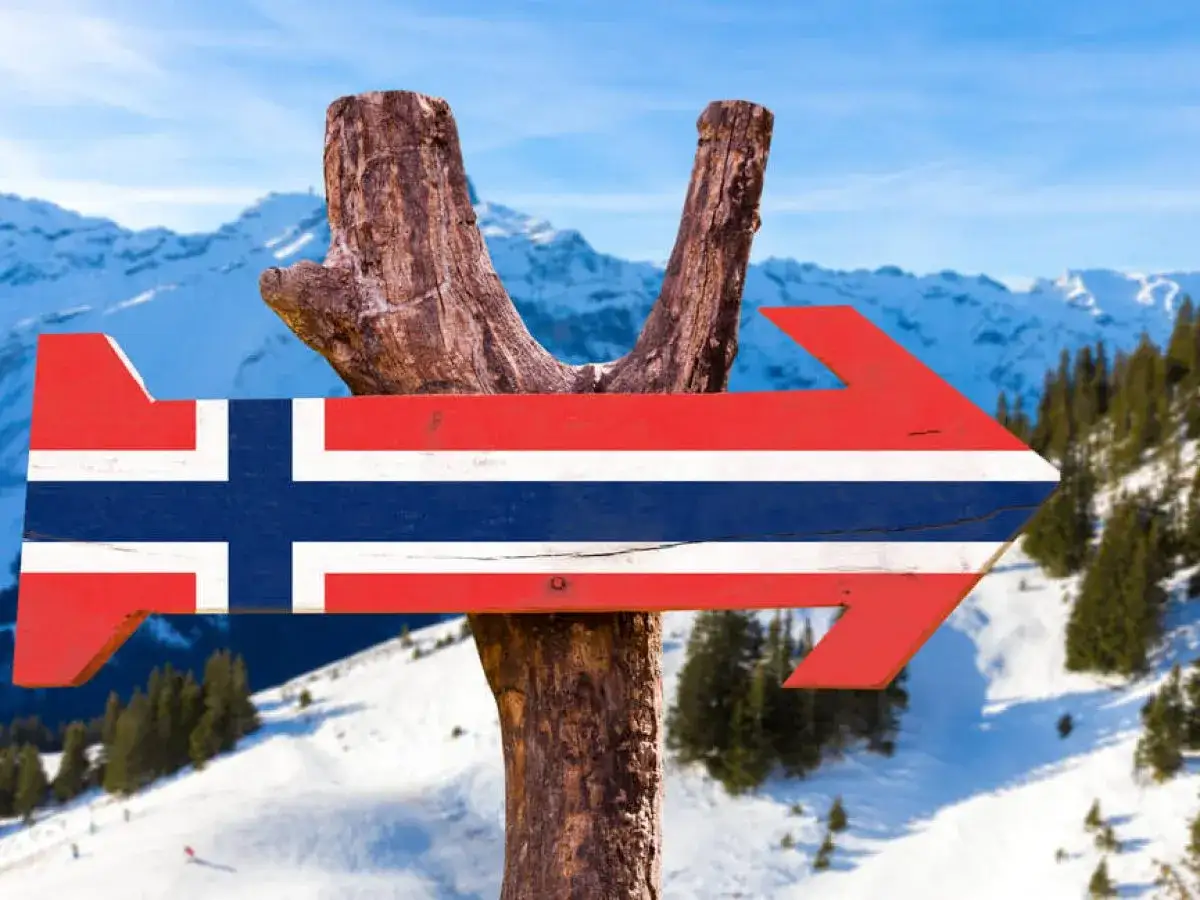 Strzałka z flagą Norwegii wskazuje drogę do narciarskich stoków. Zastanawiasz się, ile alkoholu można przewieźć samolotem do Norwegii?