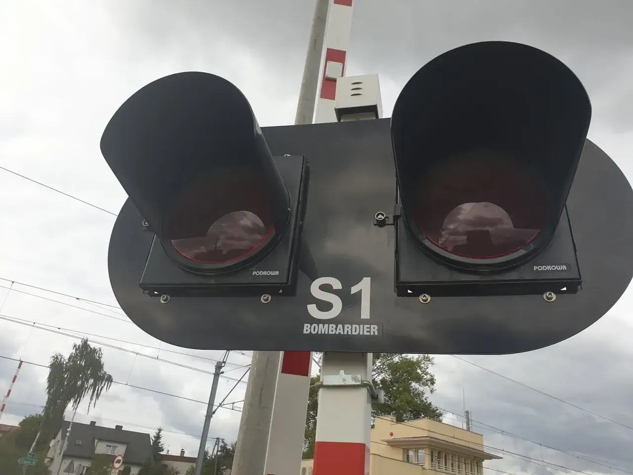 Sygnalizacja świetlna na przejeździe kolejowym świeci na czerwono, ostrzegając przed nadjeżdżającym pociągiem. Wjazd na przejazd kolejowy na czerwonym świetle jest zabroniony.