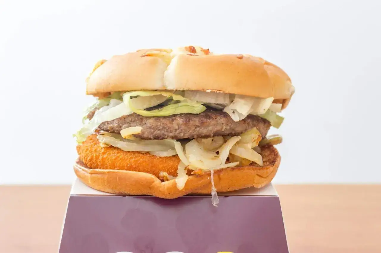 Apetyczny burger drwala podwójny z soczystym mięsem, chrupiącą panierką, sałatą i cebulką.