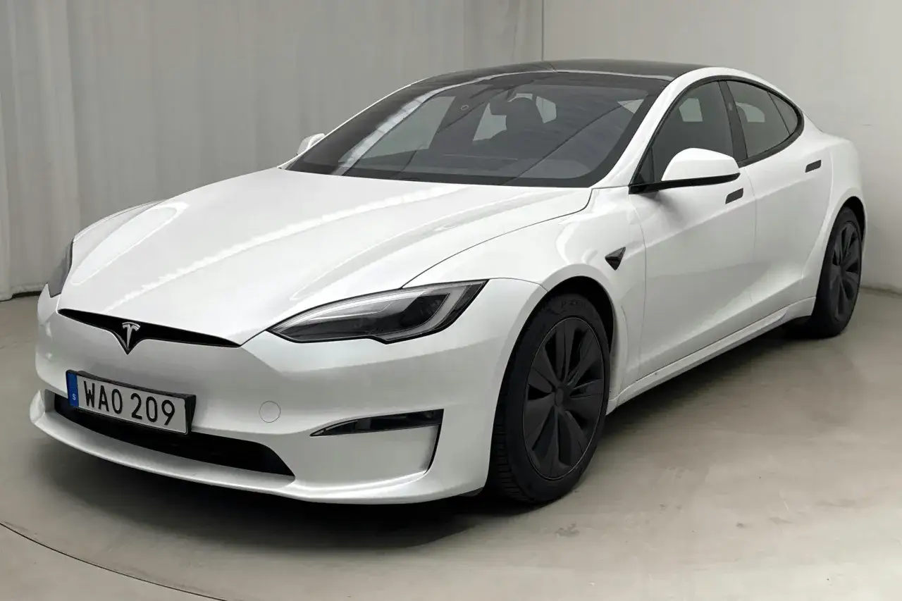 Vit Tesla Model S begagnad med svarta f&auml;lgar och tak. En elegant elbil redo f&ouml;r nya &auml;ventyr.