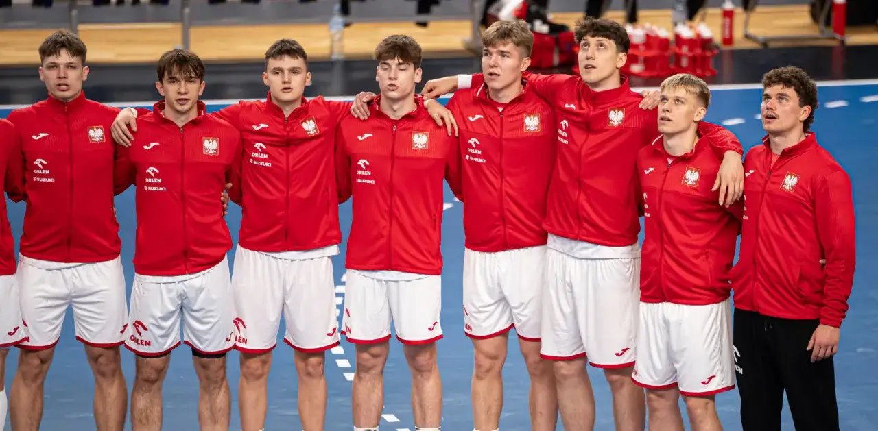 Młodzi zawodnicy w czerwonych strojach z orłem na piersiach, gotowi do gry w lidze piłki ręcznej.