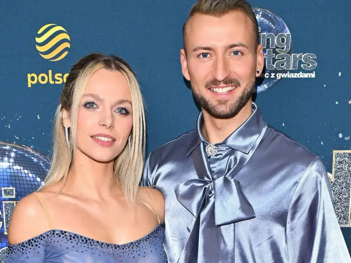 Michał Bartkiewicz i jego partnerka na ściance. Widać ich uśmiechy i eleganckie stroje. Prywatne chwile z życia gwiazd.