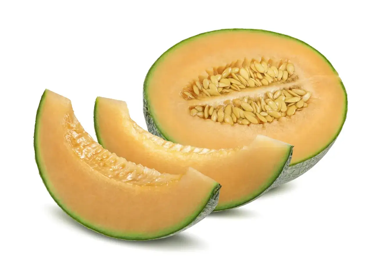 Kawałek i połówka melona kantalupa z pestkami. Czy melon jest lekkostrawny? Tak, jest to owoc łatwo przyswajalny.