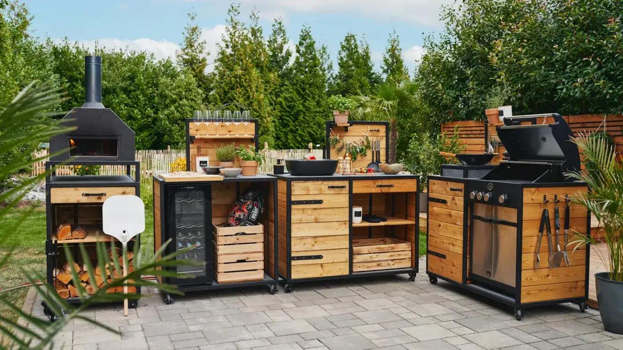 Un'area cucina da giardino completa con forno per pizza, griglia, lavandino fai da te e cantinetta.
