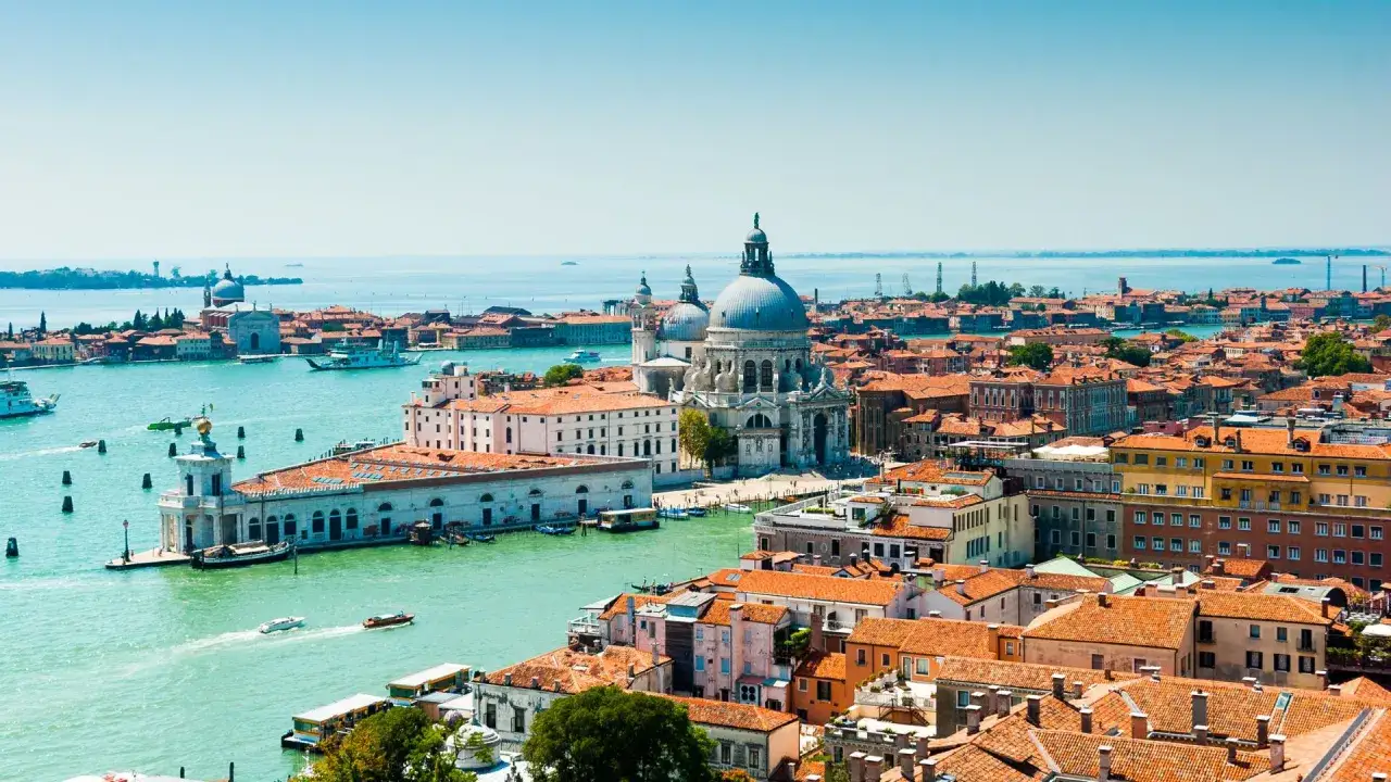 Widok na Wenecję z kanałem i kościołem Santa Maria della Salute. Zastanawiasz się, ile trwa podróż do Włoch autokarem?