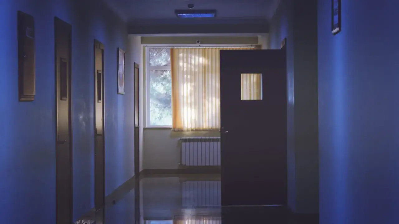 Długi, pusty korytarz szpitala psychiatrycznego, gdzie każdy dzień może oznaczać dożywotni pobyt w zamknięciu.
