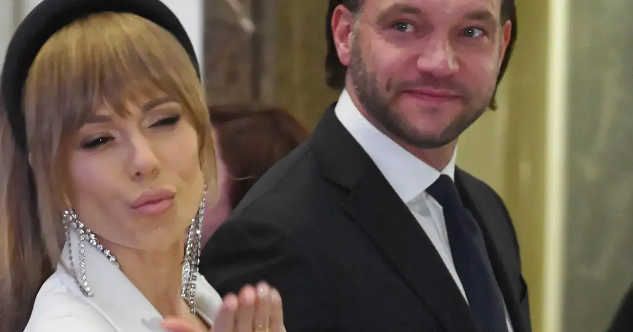Doda i Emil Stępień na evencie. Ona w białej marynarce i błyszczących kolczykach, on w garniturze.
