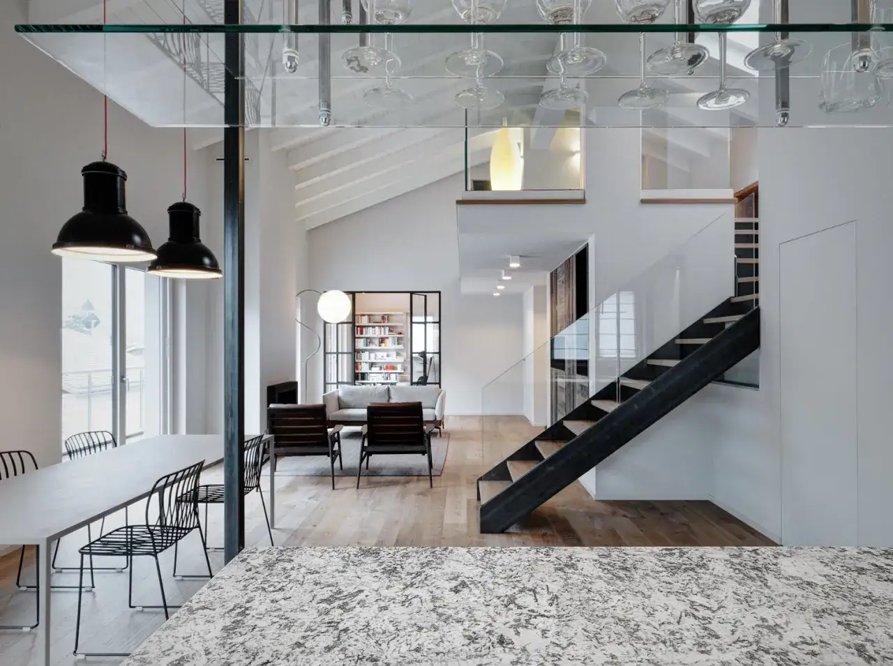 Interno di una casa due piani moderna con zona pranzo, soggiorno e scala a vista.